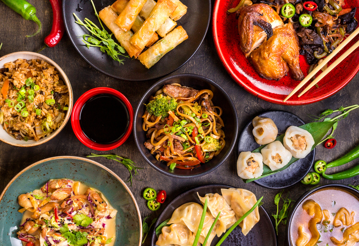 Assorted Chinese food set. Chinese noodles, fried rice, dumplings, peking duck, dim sum, spring rolls. Famous Chinese cuisine dishes on table. Top view. Chinese restaurant concept. Asian style banquet