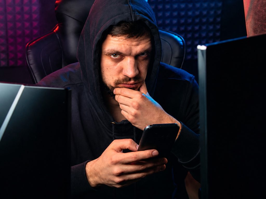 How to avoid unlicensed online casinos in the UK Person checking online casino safety on a phone and computer