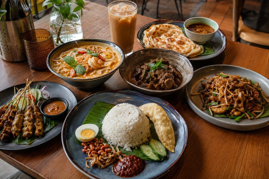 The Best Malaysian Restaurants in Manchester 2026 Malaysian food spread with nasi lemak, laksa, rendang, satay and roti canai