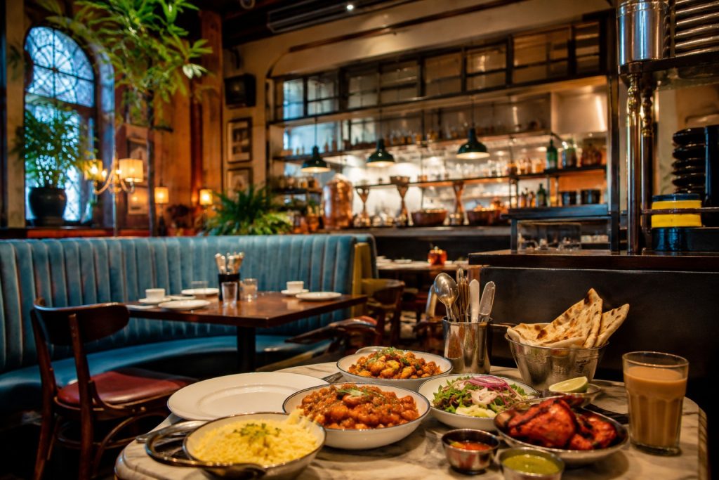 Dishoom Leeds: Everything You Need to Know Before You Visit Indian restaurant table with curry, rice, naan and chai in a warm Leeds dining setting