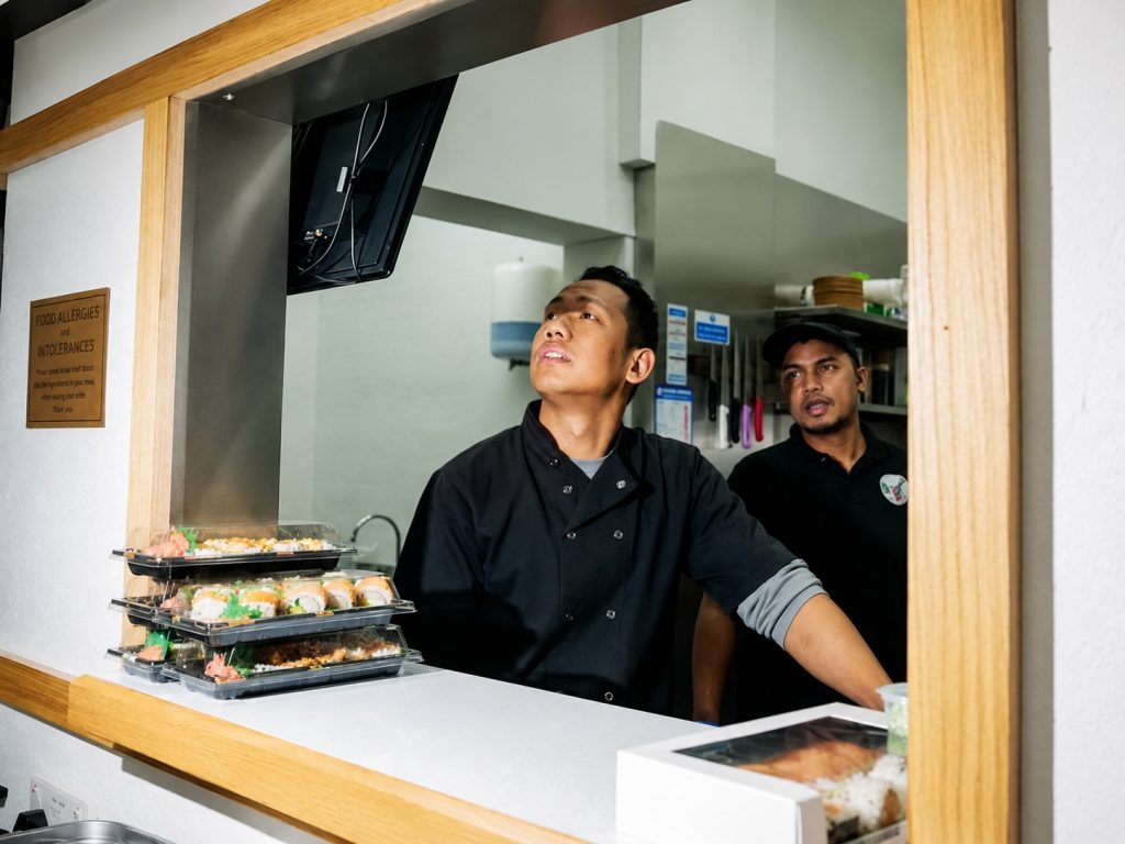 Restaurant staff using a digital order management system in a busy kitchen